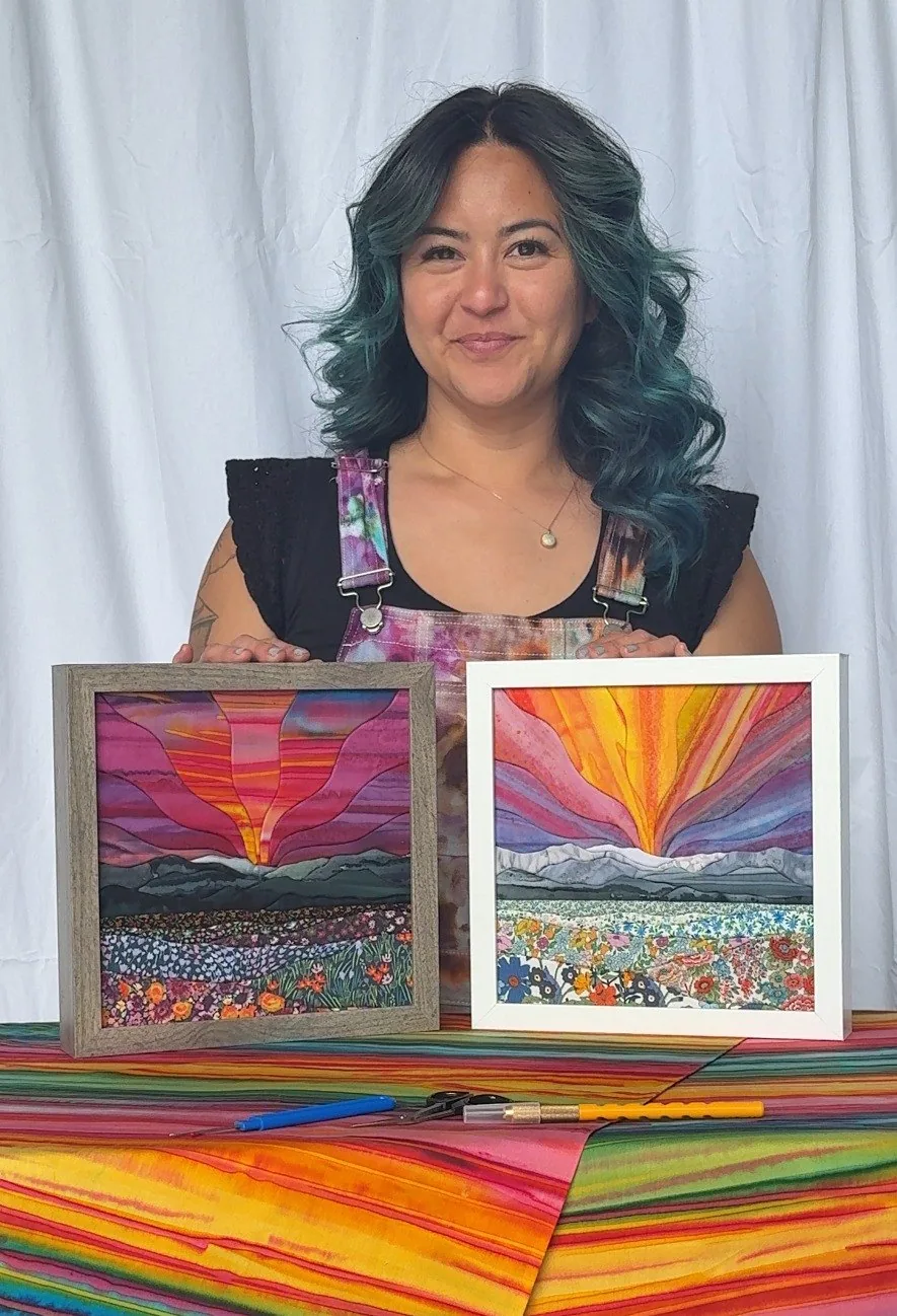 Hannah Austin holding two of her finished kinusaiga landscapes